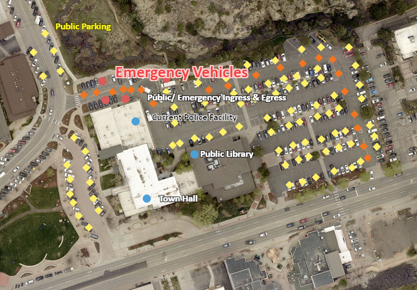 Aerial view of the current police facility at Town Hall, with police vehicles parked in a public lot at the public entrance. 
