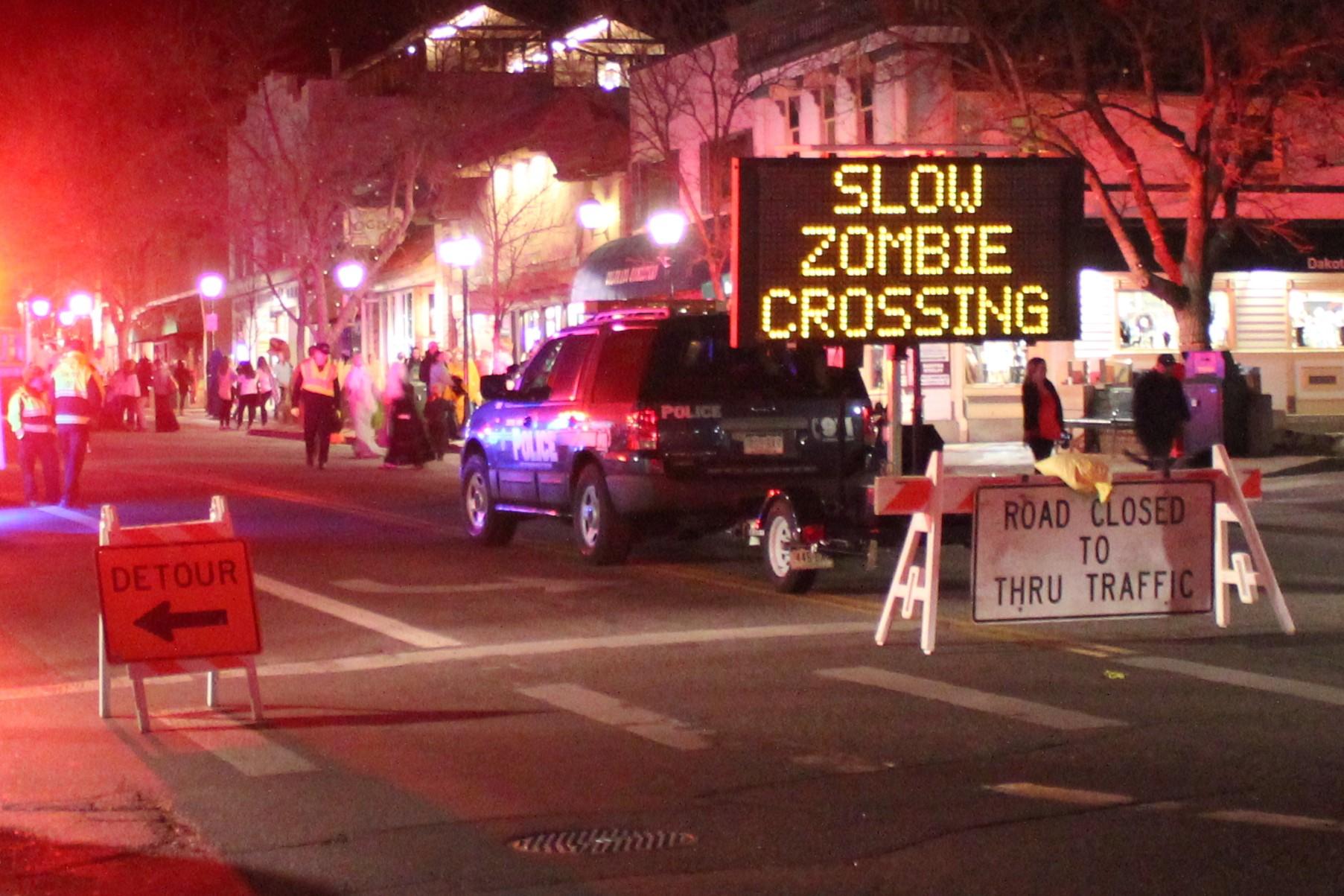 "Slow zombie crossing" sign during downtown Halloween celebration
