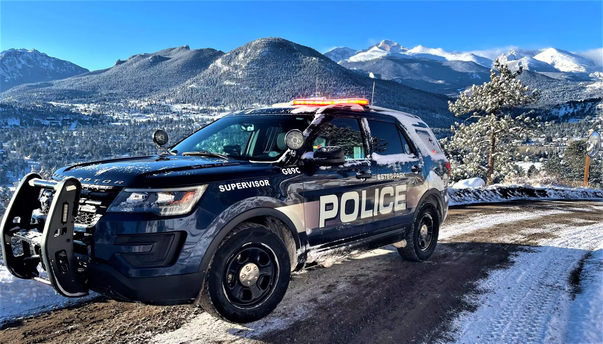 Estes Park Police patrol vehicle with snow capped peaks in background