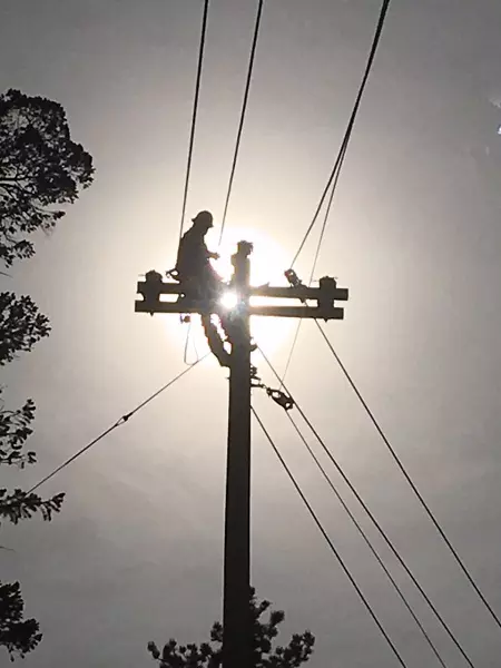 Lineman backlit by the sun
