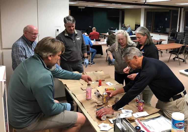 Community Police Academy participants engaging in a tabletop fingerprinting exercise